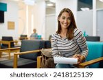 Young happy woman writing her data on medical documents while waiting for doctor