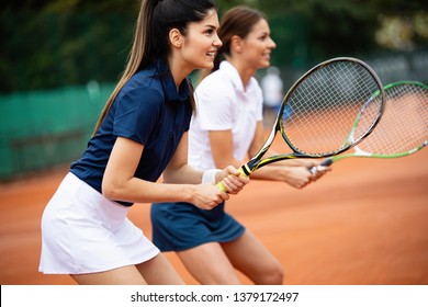 Young happy women friends playing tennis at tennis court - Powered by Shutterstock