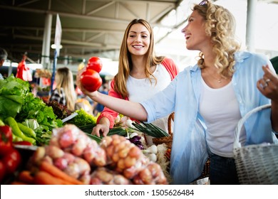 Young happy women shopping vegetables and fruits on the market - Powered by Shutterstock