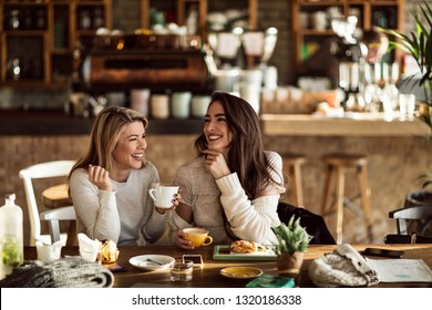 Young happy women talking and laughing while drinking coffee together in coffee shop. - Powered by Shutterstock