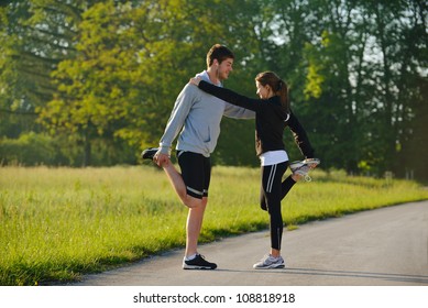 young health couple doing stretching exercise relaxing and warm up after jogging and running in park Stock Photo