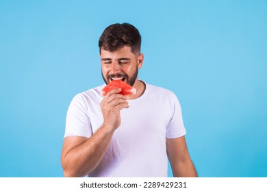 Young healthy handsome boy eating watermelon