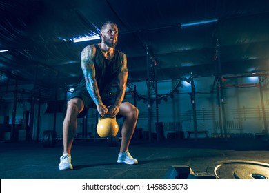 Young Healthy Man Athlete Doing Exercise With The Weights In The Gym. Single Male Model Training Hard And Practicing In Squats. Concept Of Healthy Lifestyle, Sport, Fitness, Bodybuilding.