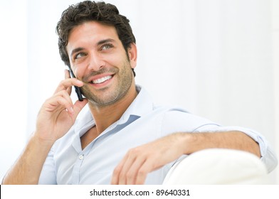 Young And Healthy Man Smiling And Talking On Smart Phone At Home