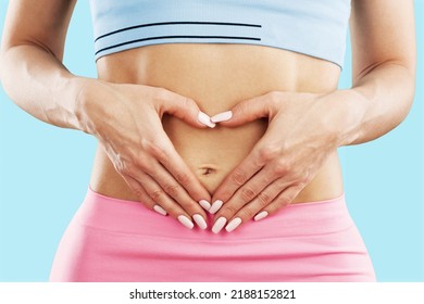 Young healthy woman hand made heart shape on her stomach. Concept of good digestive, healthy gut, probiotics, slim fit, gynecology and woman health care. - Shutterstock ID 2188152821