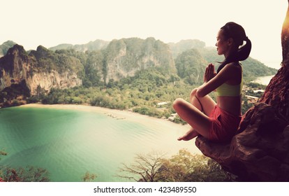 young healthy woman practice yoga on mountain peak cliff - Powered by Shutterstock