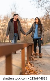 Young Heterosexual Couple Walking In A Park And Talking