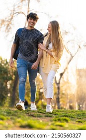 Young Heterosexual Couple Walking In A Park And Talking