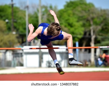 Young High School Boy Competing In The High Jump At A Track Meet