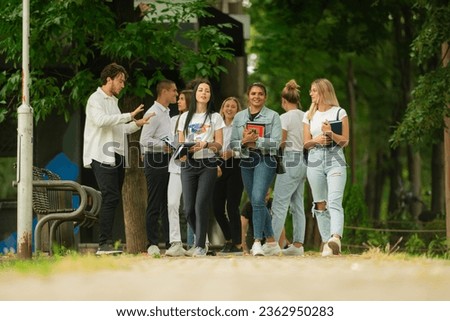 Similar – Multiethnic friends resting outside food truck in evening