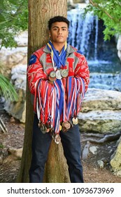 Young High School Senior Athlete With Letter Jacket And Medals Posing For Senior Photos