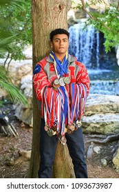 Young High School Senior Athlete With Letter Jacket And Medals Posing For Senior Photos