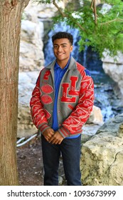 Young High School Senior Athlete With Letter Jacket And Medals Posing For Senior Photos