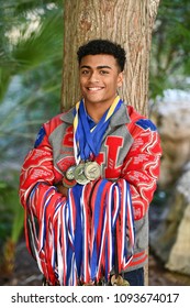 Young High School Senior Athlete With Letter Jacket And Medals Posing For Senior Photos