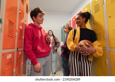 Young high school students meeting and greeting near locker in campus hallway, back to school concept. - Shutterstock ID 2190204289