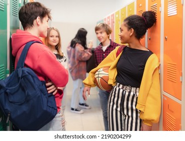 Young high school students meeting and greeting near locker in campus hallway, back to school concept. - Shutterstock ID 2190204299