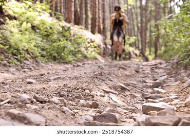 Young hiker with backpack in forest, selective focus. Space for text