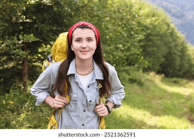 Young hiker with backpack in forest, space for text