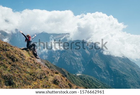 Young hiker backpacker female rising her arms,cheerful laughing and enjoying valley during high altitude Everest Base Camp (EBC) trekking route near Namche Bazaar,Nepal. Active vacations concept image 商業照片 © 