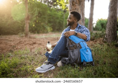 Young hiker drinking energy drink while enjoys resting in nature. - Powered by Shutterstock