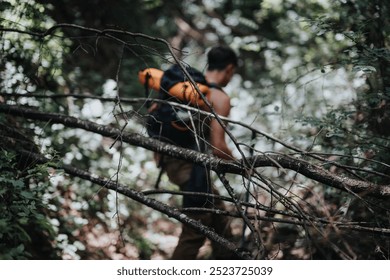 Young hiker exploring a dense forest during a sunny summer day, enjoying an adventure and outdoor nature experience. - Powered by Shutterstock