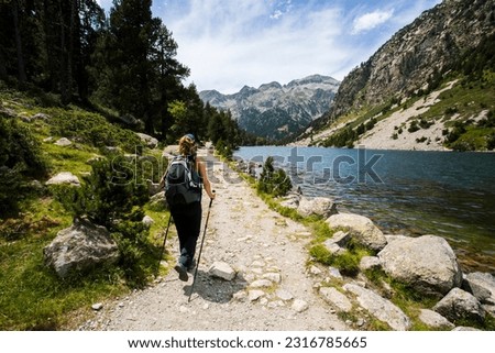 Young hiker woman in Vall de Boi in Aiguestortes and Sant Maurici National Park, Pyrenees, Spain