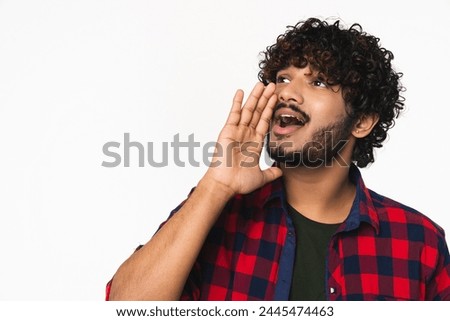 Young Hindi man shouting with hand isolated over white background. Indian boy in casual clothes telling secrets, news with copyspace.