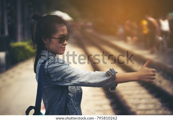 Young\
hippie woman hitchhiking on the Railroad\
track.
