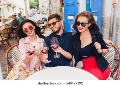 Young Hipster Company Of Friends Sitting At Cafe, Drinking Wine On Europe Vacation, Sunglasses, Happy, Smiling, Party, Summer Style, Toasting, Positive, Alcohol