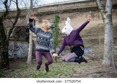 Young Hipster Couple Lovers Rabbit And Horse Mask At The Park