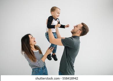 Junge Hip-Vater, Mutter, die einen süßen Baby hält, auf betoniertem Boden auf weißem Hintergrund