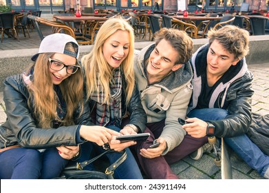 Young Hipster Friends Group Having Genuine Fun Together Using Mobile Phone - Friendship Hang Out Concept With Technology Interaction In Always Connected Lifestyle - Internet Connection Spots Outdoors