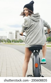 Young Hipster Girl With Black Bike Back To Camera. Outdoor Lifestyle Portrait