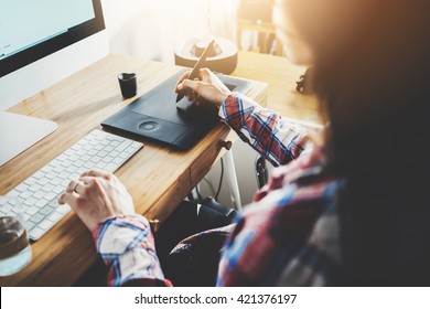 Young Hipster Girl Sitting At Her Workspace And Using Modern Computer And Digital Graphic Tablet While Working At Vintage Loft, Professional Female Graphic Designer Working At Home, Flare Light