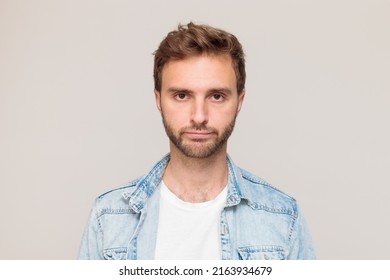 Young Hipster Male With Stubble In A White T-shirt And Light Blue Denim Shirt. Emotion - Disappointment, No Mood, Despair. On A Light Gray Background