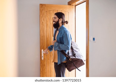 Young Hipster Man With Bag Entering Front Door When Coming Back Home.