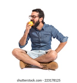 Young Hipster Man Eating Apple Over White Background