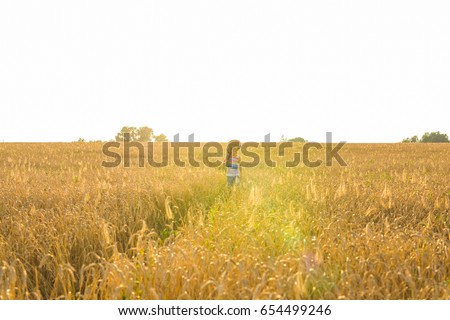 Similar – Woman alone in a field of wheat