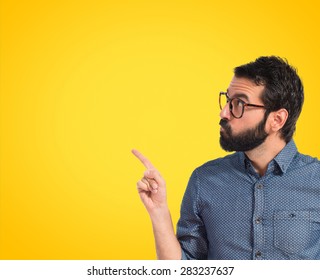 Young hipster man thinking over colorful background