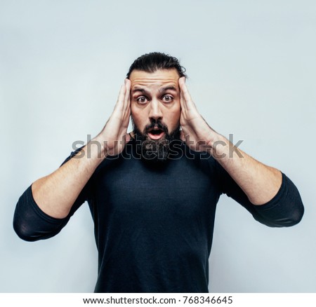 Young hipster man wearing casual blue t-shirt staring at camera with shocked look, expressing astonishment and shock, screaming "Omg" or "Wow". disappointment. Crazy emotions. surprise.
The emotional 