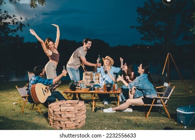 Young hipster people having fun to music dining and drinking together in campsite - Travel vacation lifestyle and youth culture concept, Happy friends group toasting beers at barbecue camping party - Powered by Shutterstock