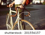 Young hipster style man posing with bicycle on the street sport style picture handsome guy with red backpack ready for trip  