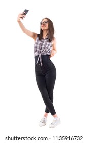 Young Hipster Style Teenage Woman Taking Photo Smiling And Posing For Selfie. Full Body Isolated On White Background.