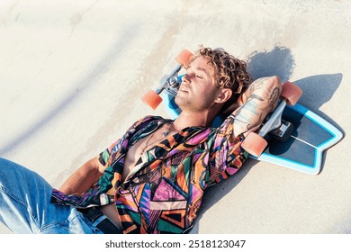 young hipster tattooed male lying with skateboard - Powered by Shutterstock