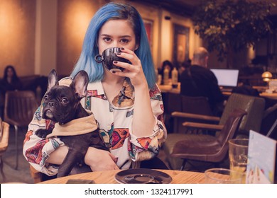 Young Hipster Woman In Cafe With Dog Drinking Coffee 