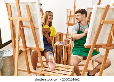 Young Hispanic Artist Couple Smiling Happy Drawing At Art Studio.