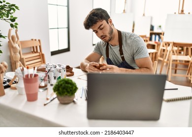 Young Hispanic Artist Man Having Online Art Class Using Laptop At Studio.