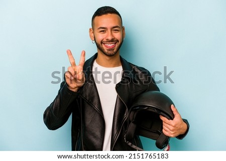 Young hispanic biker man isolated on blue background showing number two with fingers.