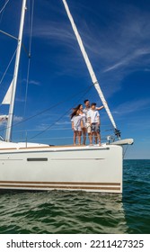 Young Hispanic Brother And Sister Enjoying Luxury Family Vacation With Parents Standing Together On Bow Of Private Yacht