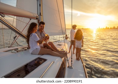 Young Hispanic Brother And Sister Watching The Sunset From Luxury Yacht With Parents Relaxing On Deck Enjoying Togetherness